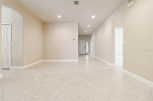2262 Lune Ct, Melbourne, FL 32904 - empty room featuring recessed lighting, light marble finish floors, arched walkways, and baseboards