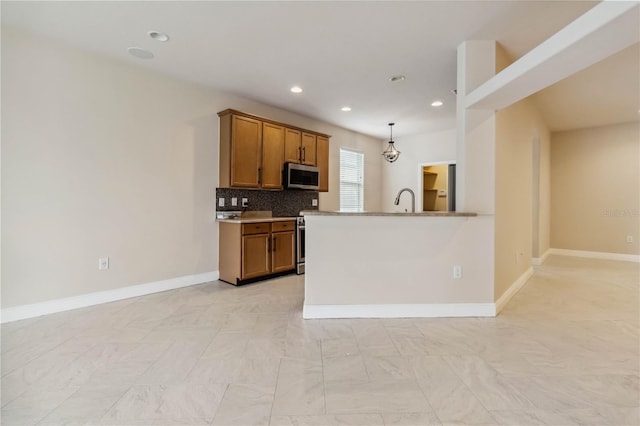 2262 Lune Ct, Melbourne, FL 32904 - kitchen with stainless steel appliances, brown cabinets, recessed lighting, baseboards, and decorative backsplash