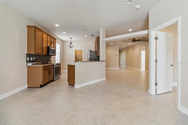 2262 Lune Ct, Melbourne, FL 32904 - kitchen with appliances with stainless steel finishes, brown cabinets, open floor plan, recessed lighting, and hanging light fixtures