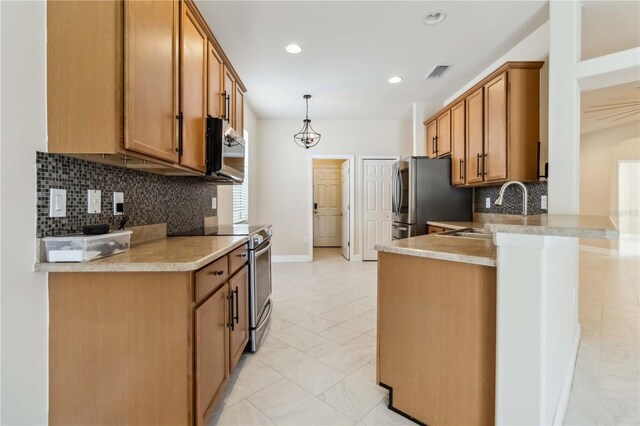 2262 Lune Ct, Melbourne, FL 32904 - kitchen with a sink, appliances with stainless steel finishes, brown cabinets, a peninsula, and tasteful backsplash