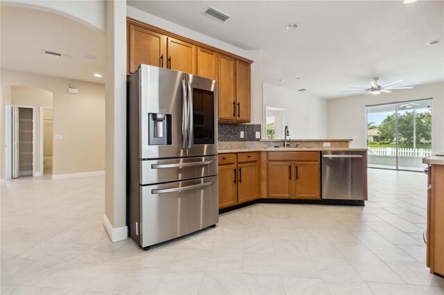 2262 Lune Ct, Melbourne, FL 32904 - kitchen featuring stainless steel appliances, a sink, brown cabinetry, a peninsula, and recessed lighting