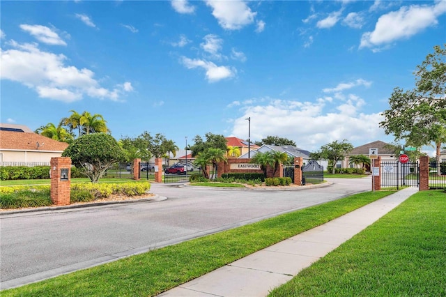 2262 Lune Ct, Melbourne, FL 32904 - view of asphalt street featuring a gate, traffic signs, a gated entry, and curbs