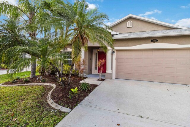 2262 Lune Ct, Melbourne, FL 32904 - view of front of home featuring stucco siding, a garage, and driveway