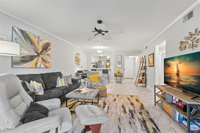 living room with marble finish floors, ornamental molding, a ceiling fan, and baseboards