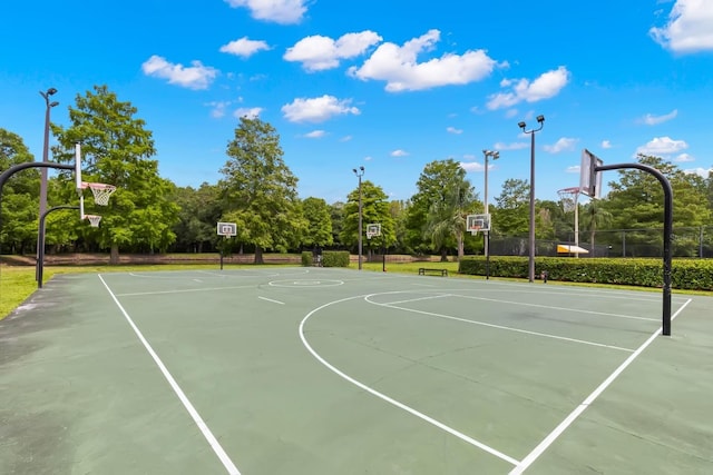view of sport court with community basketball court, view of scattered trees, and fence