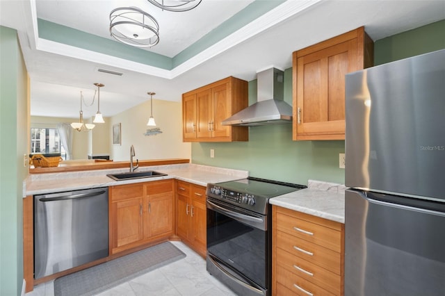 143 Lakeside Dr Unit 143, Oldsmar, FL 34677 - kitchen featuring appliances with stainless steel finishes, a sink, wall chimney exhaust hood, light countertops, and hanging light fixtures