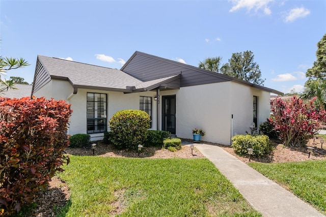 322 Windrush Loop Unit 22, Tarpon Springs, FL 34689 - view of front of home featuring a front yard, stucco siding, and roof with shingles