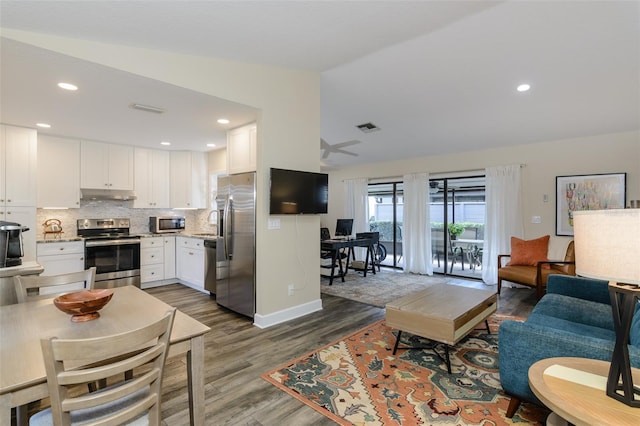 322 Windrush Loop Unit 22, Tarpon Springs, FL 34689 - living area with wood finished floors, vaulted ceiling, a desk, and recessed lighting