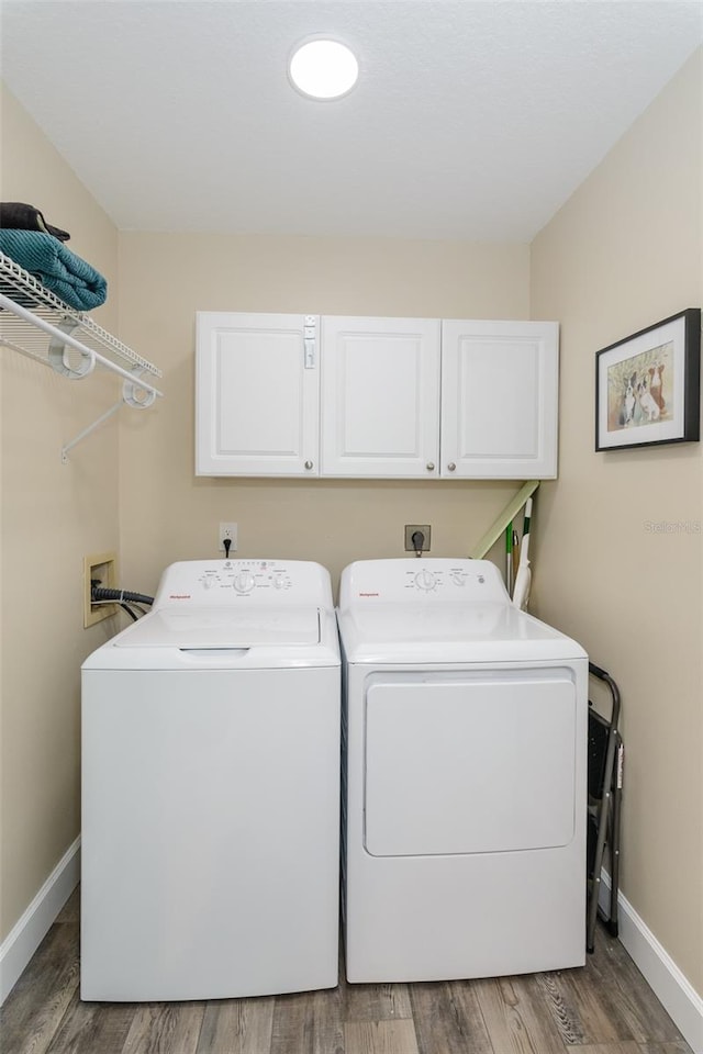 322 Windrush Loop Unit 22, Tarpon Springs, FL 34689 - washroom featuring cabinet space, washing machine and clothes dryer, baseboards, and light wood finished floors