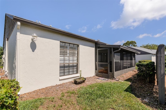 322 Windrush Loop Unit 22, Tarpon Springs, FL 34689 - rear view of property with a sunroom and stucco siding