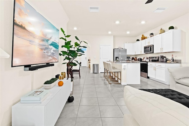 2906 Boxwood Grove Row, Wesley Chapel, FL 33543 - kitchen with appliances with stainless steel finishes, a breakfast bar, recessed lighting, a kitchen island with sink, and white cabinetry