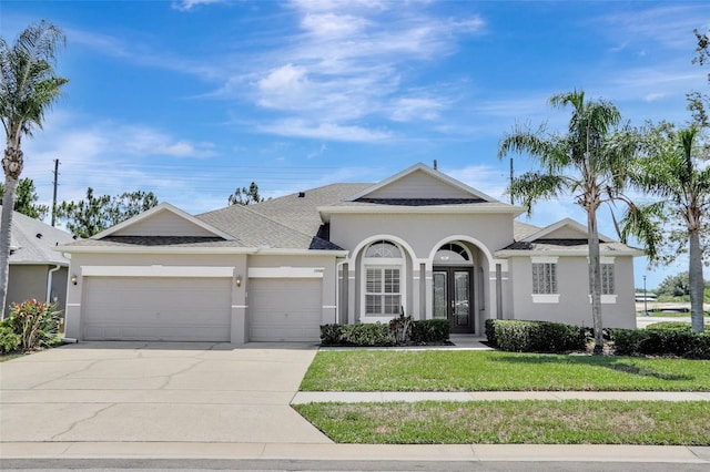 13708 Old Dock Rd, Orlando, FL 32828 - view of front of house featuring french doors, an attached garage, stucco siding, concrete driveway, and a front lawn