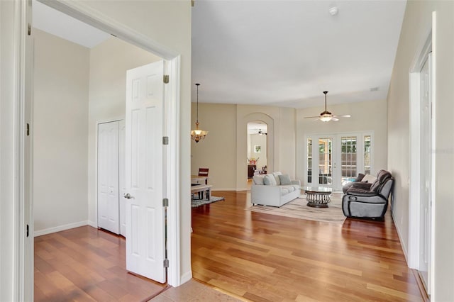13708 Old Dock Rd, Orlando, FL 32828 - living area with arched walkways, light wood-style flooring, ceiling fan, french doors, and baseboards