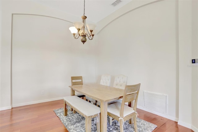 13708 Old Dock Rd, Orlando, FL 32828 - dining room with a chandelier, light wood-style floors, baseboards, and vaulted ceiling