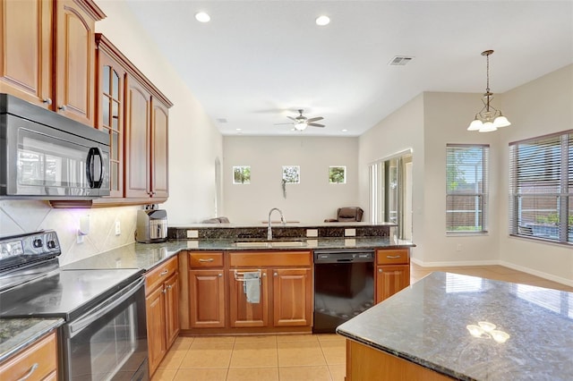 13708 Old Dock Rd, Orlando, FL 32828 - kitchen featuring black appliances, a sink, a peninsula, dark stone counters, and hanging light fixtures