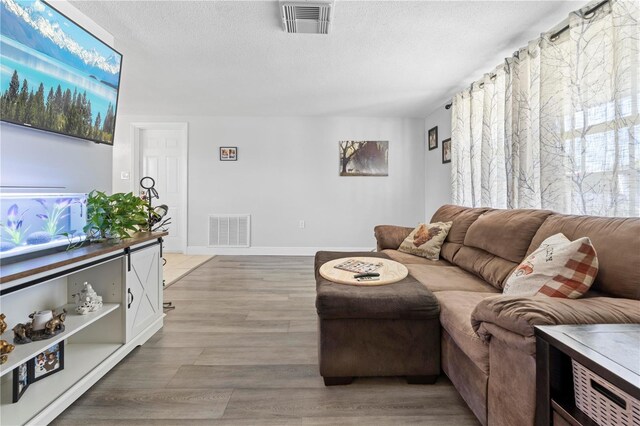 9126 Greenbriar Ln, Port Richey, FL 34668 - living area featuring a textured ceiling, light wood-type flooring, and baseboards