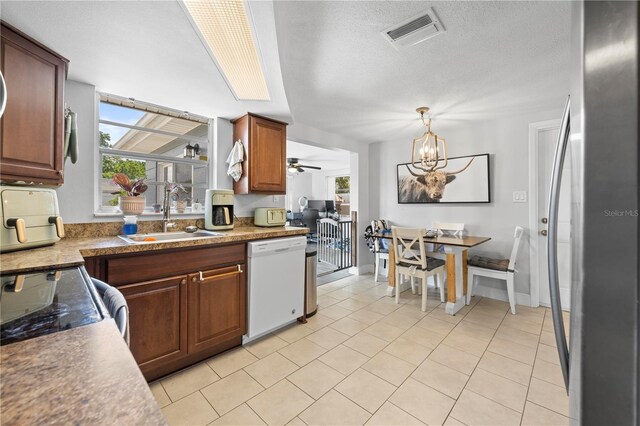9126 Greenbriar Ln, Port Richey, FL 34668 - kitchen featuring white dishwasher, a sink, freestanding refrigerator, a chandelier, and light tile patterned floors