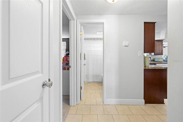 9126 Greenbriar Ln, Port Richey, FL 34668 - hall featuring a textured ceiling, light tile patterned floors, and baseboards