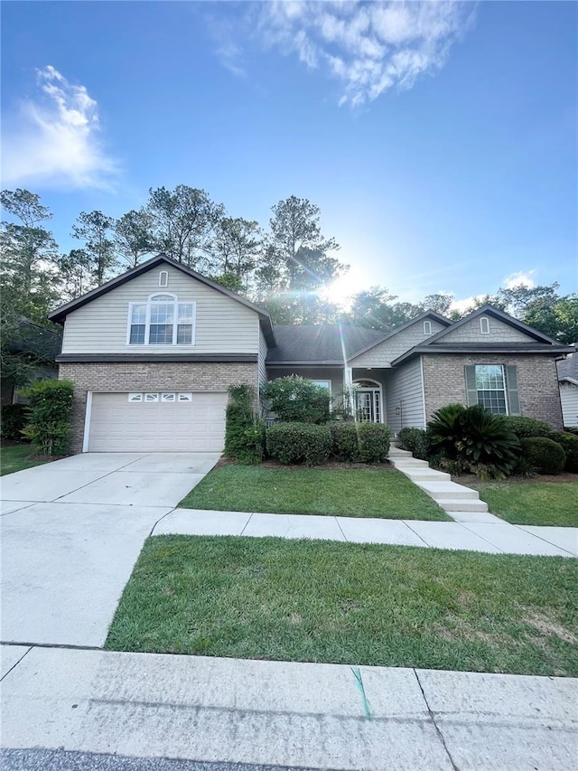 2244 NW 101st St, Gainesville, FL 32606 - view of front facade with brick siding, a garage, concrete driveway, and a front lawn