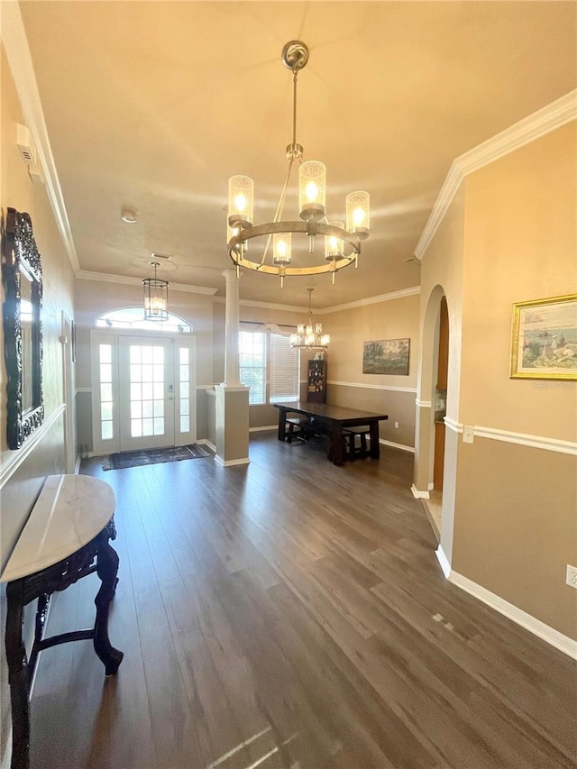 2244 NW 101st St, Gainesville, FL 32606 - hallway featuring arched walkways, a chandelier, ornamental molding, dark wood-style flooring, and baseboards