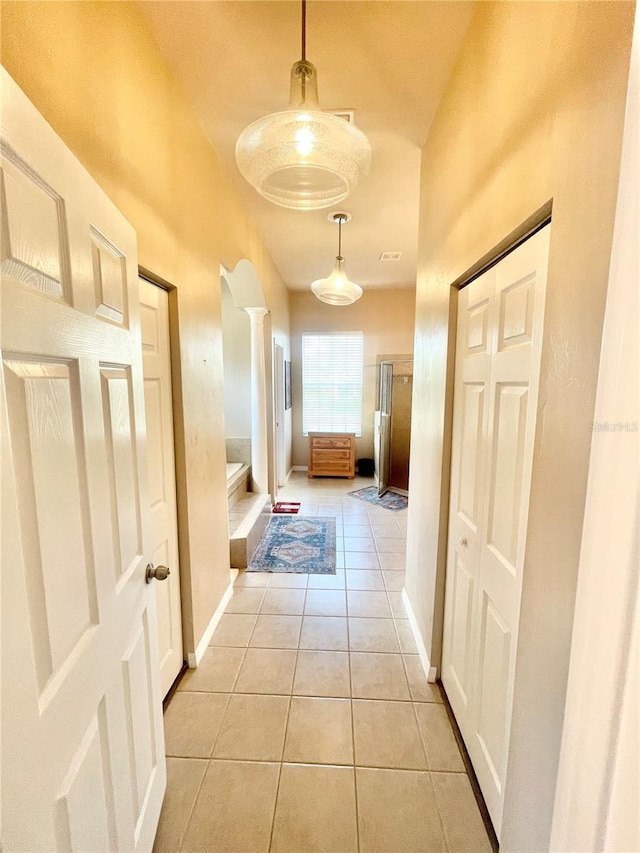 2244 NW 101st St, Gainesville, FL 32606 - hall featuring light tile patterned flooring, baseboards, and decorative columns