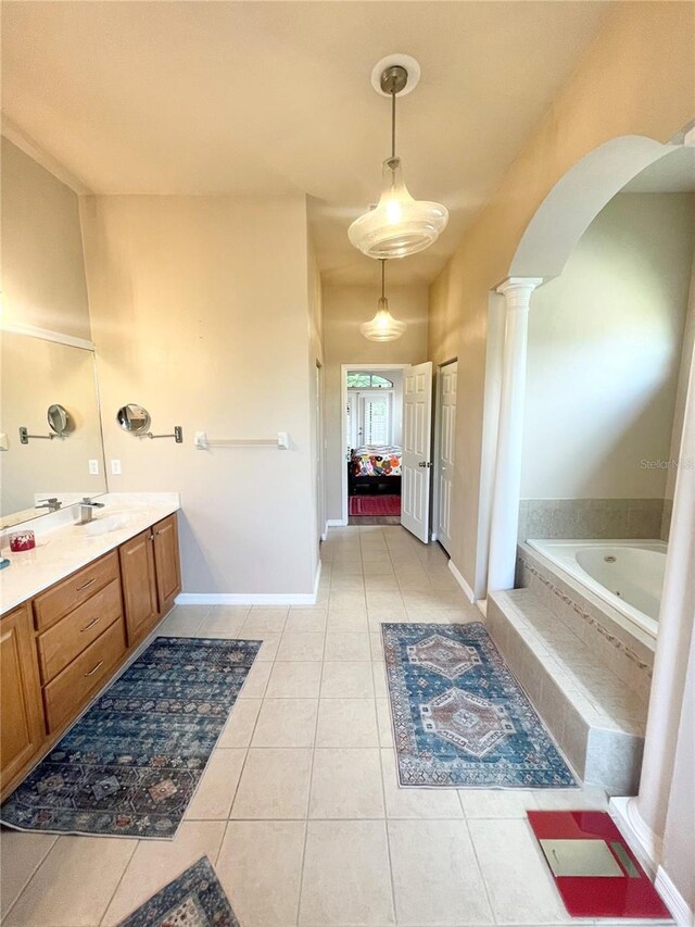 2244 NW 101st St, Gainesville, FL 32606 - bathroom with tile patterned flooring, decorative columns, tiled tub, and vanity