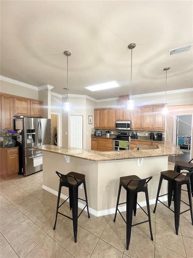 2244 NW 101st St, Gainesville, FL 32606 - kitchen with stainless steel appliances, ornamental molding, a kitchen breakfast bar, light tile patterned floors, and light stone countertops
