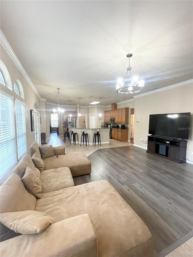 2244 NW 101st St, Gainesville, FL 32606 - living room with a chandelier, crown molding, wood finished floors, and baseboards