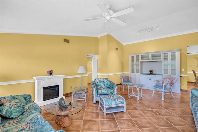 3224 Hilary Cir, Palm Harbor, FL 34684 - tiled living area with lofted ceiling, ceiling fan, a glass covered fireplace, crown molding, and rail lighting
