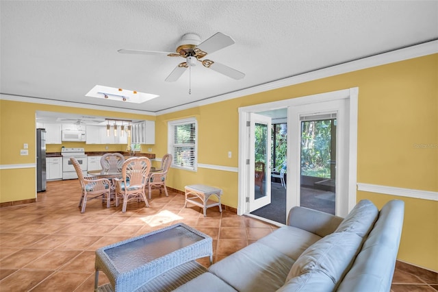 3224 Hilary Cir, Palm Harbor, FL 34684 - living area with a skylight, ceiling fan, crown molding, light tile patterned flooring, and baseboards