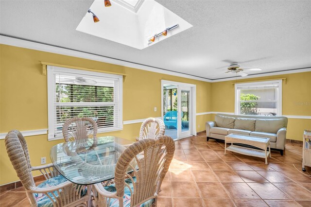 3224 Hilary Cir, Palm Harbor, FL 34684 - dining area with plenty of natural light, a skylight, light tile patterned flooring, a textured ceiling, and crown molding