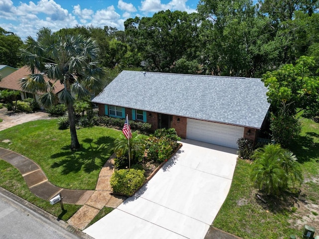 3224 Hilary Cir, Palm Harbor, FL 34684 - view of front of house featuring driveway, a front yard, brick siding, an attached garage, and roof with shingles