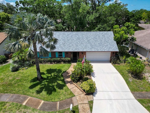 3224 Hilary Cir, Palm Harbor, FL 34684 - view of front facade with concrete driveway, brick siding, a front yard, an attached garage, and a shingled roof