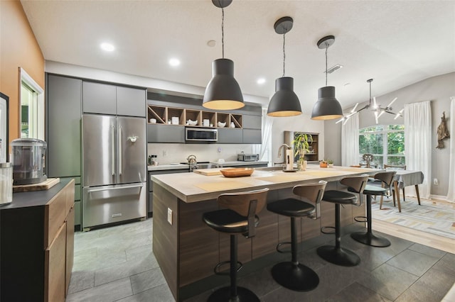 11446 Sinatra Ct, New Port Richey, FL 34654 - kitchen featuring appliances with stainless steel finishes, a center island with sink, a breakfast bar, a sink, and recessed lighting