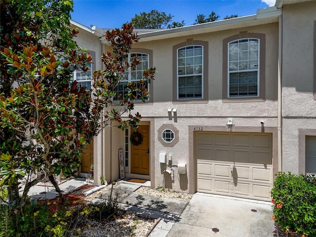 4732 Ashburn Pond Way, Tampa, FL 33610 - view of property with stucco siding, an attached garage, and concrete driveway
