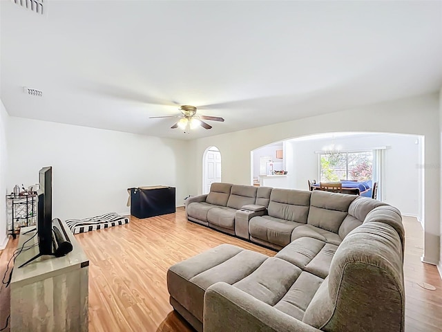 4732 Ashburn Pond Way, Tampa, FL 33610 - living room with arched walkways, wood finished floors, a chandelier, and a ceiling fan