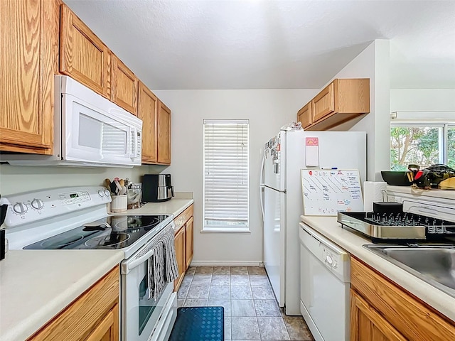 4732 Ashburn Pond Way, Tampa, FL 33610 - kitchen featuring white appliances, light countertops, and brown cabinetry