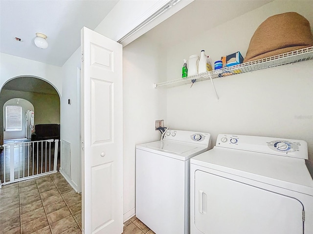 4732 Ashburn Pond Way, Tampa, FL 33610 - washroom featuring washing machine and clothes dryer, arched walkways, and light tile patterned flooring