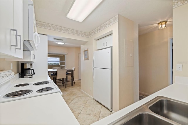 6105 Bahia Del Mar Cir Unit 683, Saint Petersburg, FL 33715 - kitchen with freestanding refrigerator, white cabinetry, light tile patterned floors, and light countertops