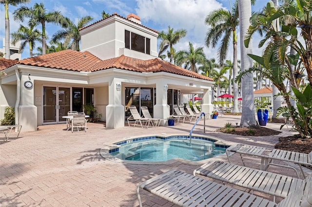 6105 Bahia Del Mar Cir Unit 683, Saint Petersburg, FL 33715 - rear view of house featuring stucco siding, a hot tub, a patio, and a tile roof