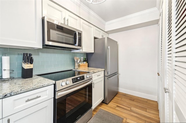 2969 Bonaventure Cir Unit 104, Palm Harbor, FL 34684 - kitchen featuring stainless steel appliances, ornamental molding, baseboards, light wood-style floors, and tasteful backsplash