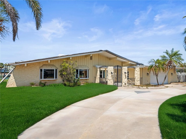 view of front of home with concrete driveway, an attached garage, and a front lawn
