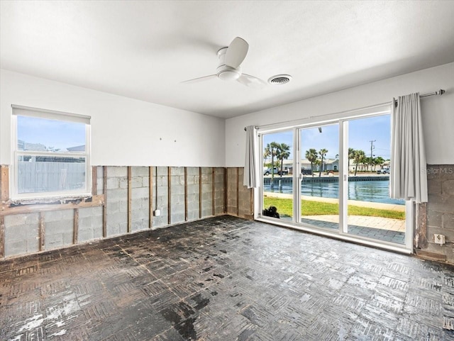 spare room featuring a ceiling fan and a water view
