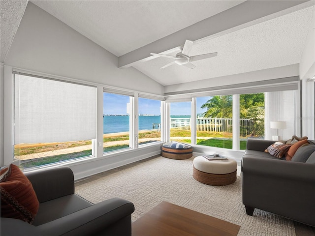 sunroom with a water view, plenty of natural light, and a textured ceiling