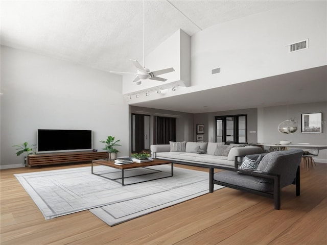 living area with wood finished floors, ceiling fan, track lighting, high vaulted ceiling, and baseboards