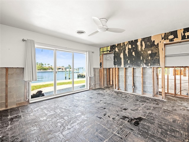 spare room with a ceiling fan and a water view