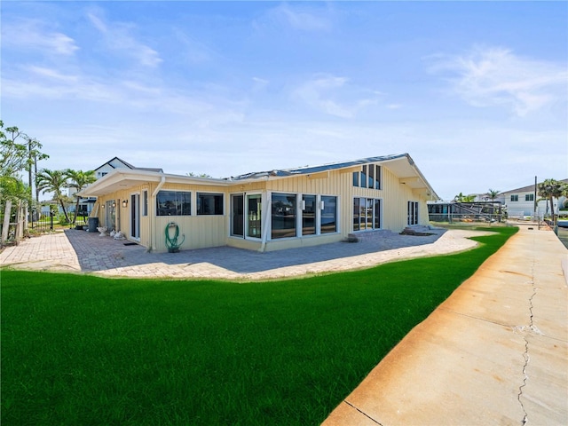 rear view of house with a lawn and a patio area