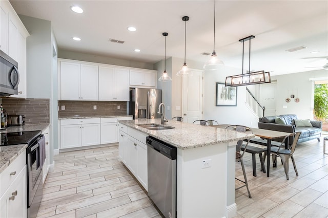 17847 Althea Blue Pl, Lutz, FL 33558 - kitchen featuring stainless steel appliances, a breakfast bar area, a sink, decorative backsplash, and open floor plan