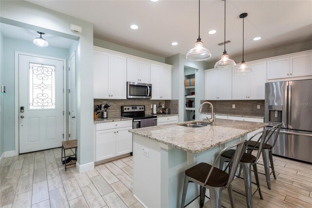 17847 Althea Blue Pl, Lutz, FL 33558 - kitchen with stainless steel appliances, a sink, decorative backsplash, a kitchen breakfast bar, and recessed lighting