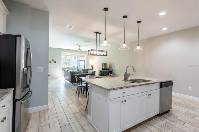 17847 Althea Blue Pl, Lutz, FL 33558 - kitchen featuring appliances with stainless steel finishes, a sink, ceiling fan, wood tiled floors, and baseboards